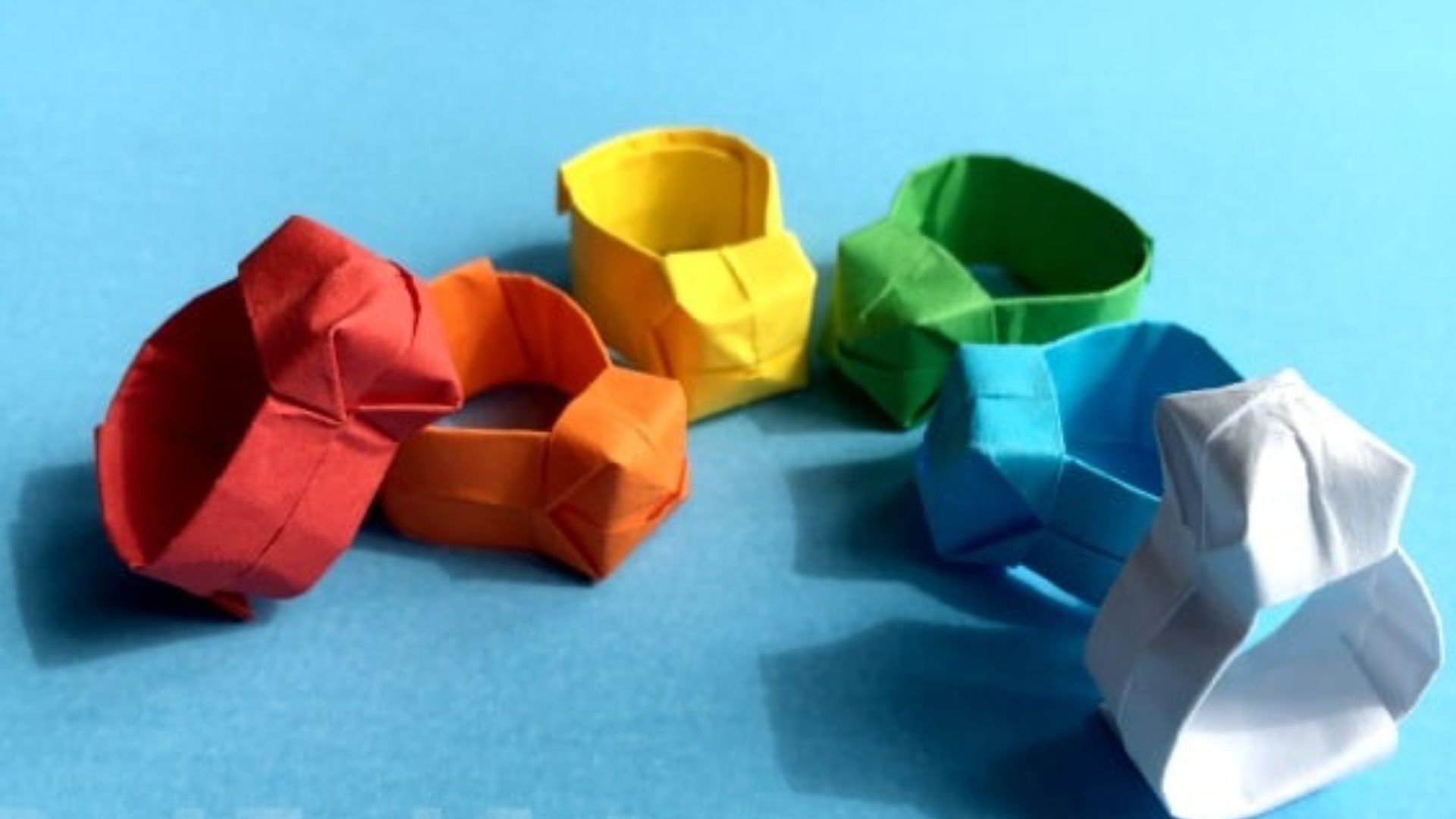 Step-by-step guide on creating a paper ring, featuring folding techniques and materials needed for crafting.