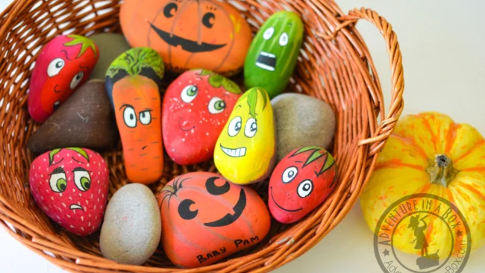 A basket filled with colorful painted rocks, each featuring unique, expressive faces.