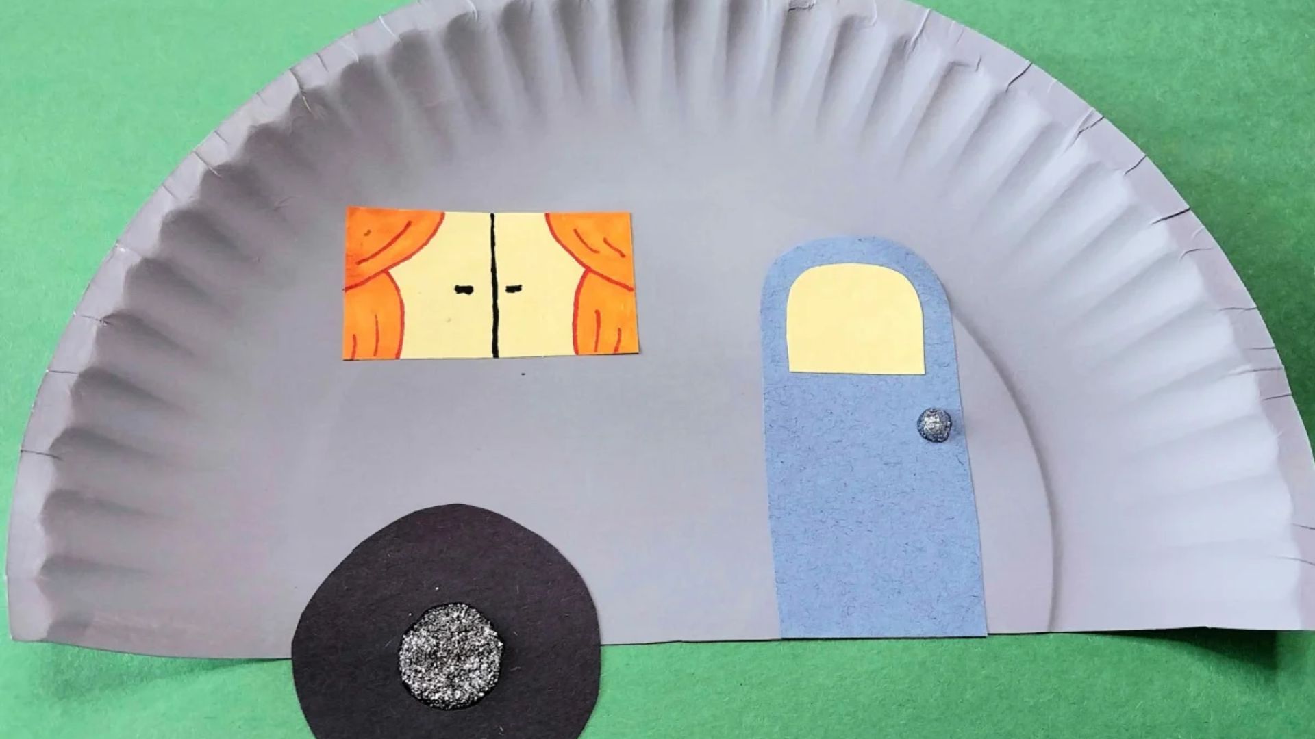 A colorful paper plate house craft made by kids, featuring a roof, windows, and a door, showcasing creativity and fun.