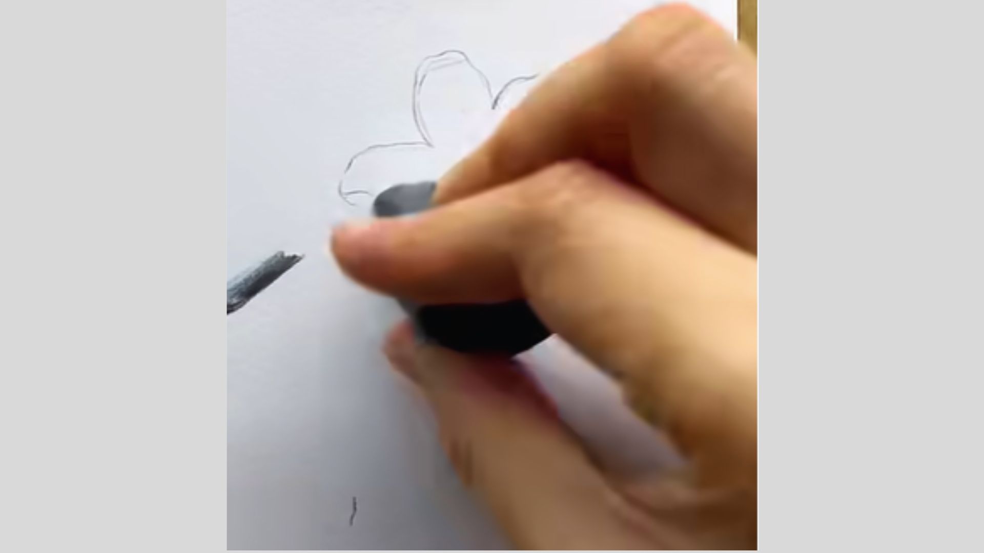 An individual drawing a flower on paper, showcasing their artistic skills and creativity.