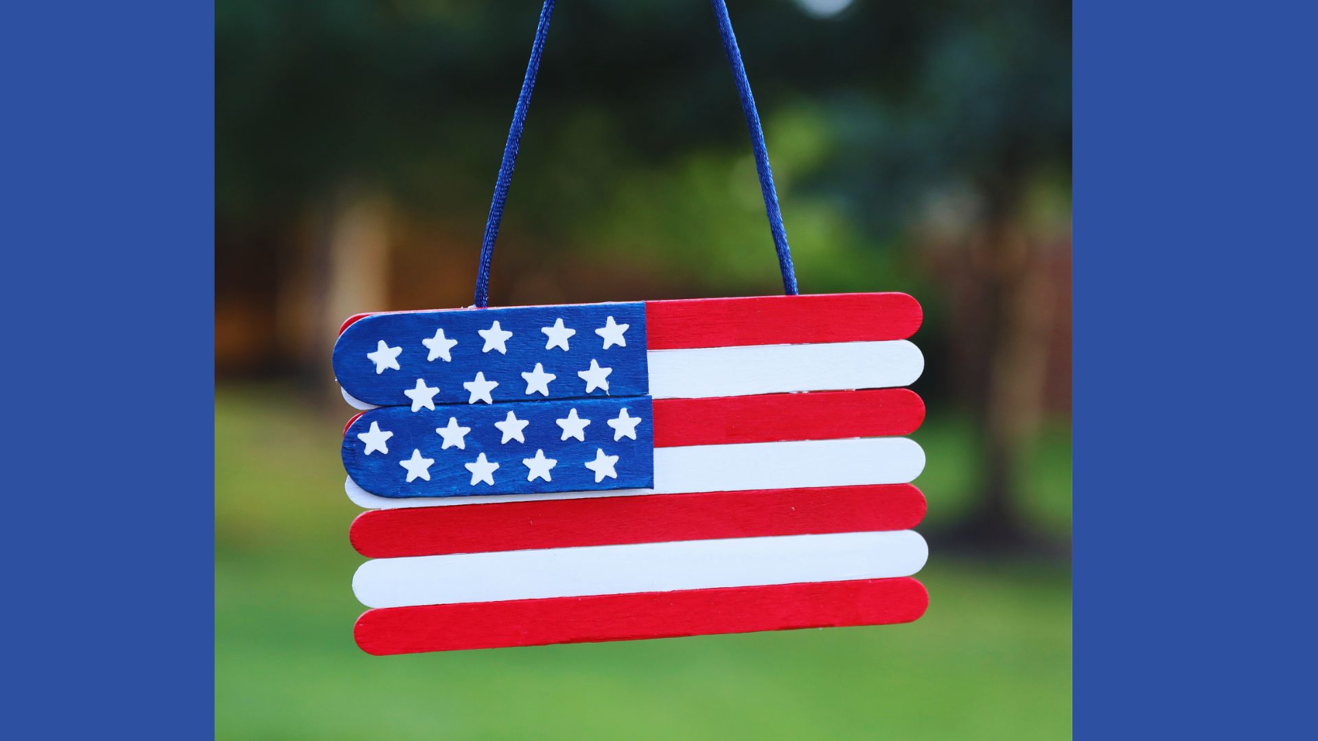 A colorful American flag crafted from popsicle sticks, hanging from a string, symbolizing patriotism.