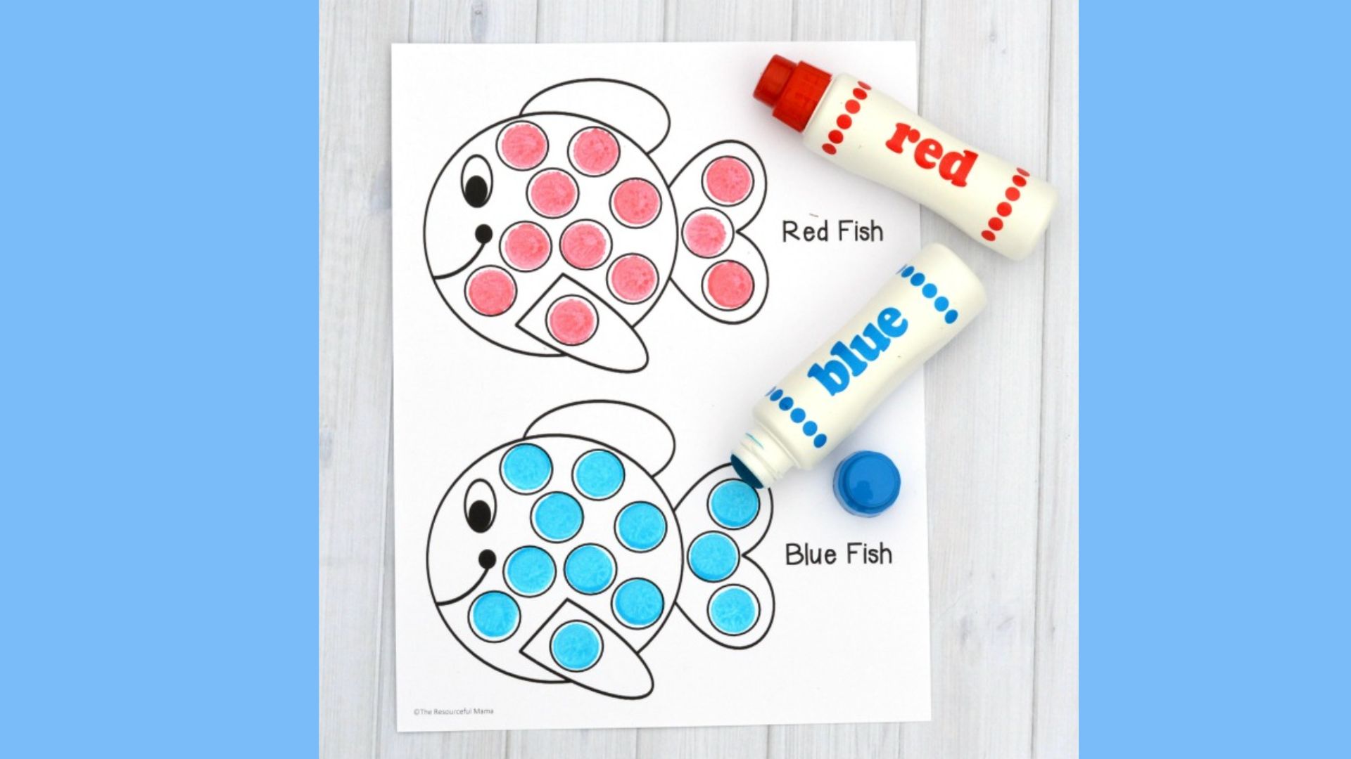 A colorful fish-themed activity featuring various markers and crayons arranged on a table for creative use.