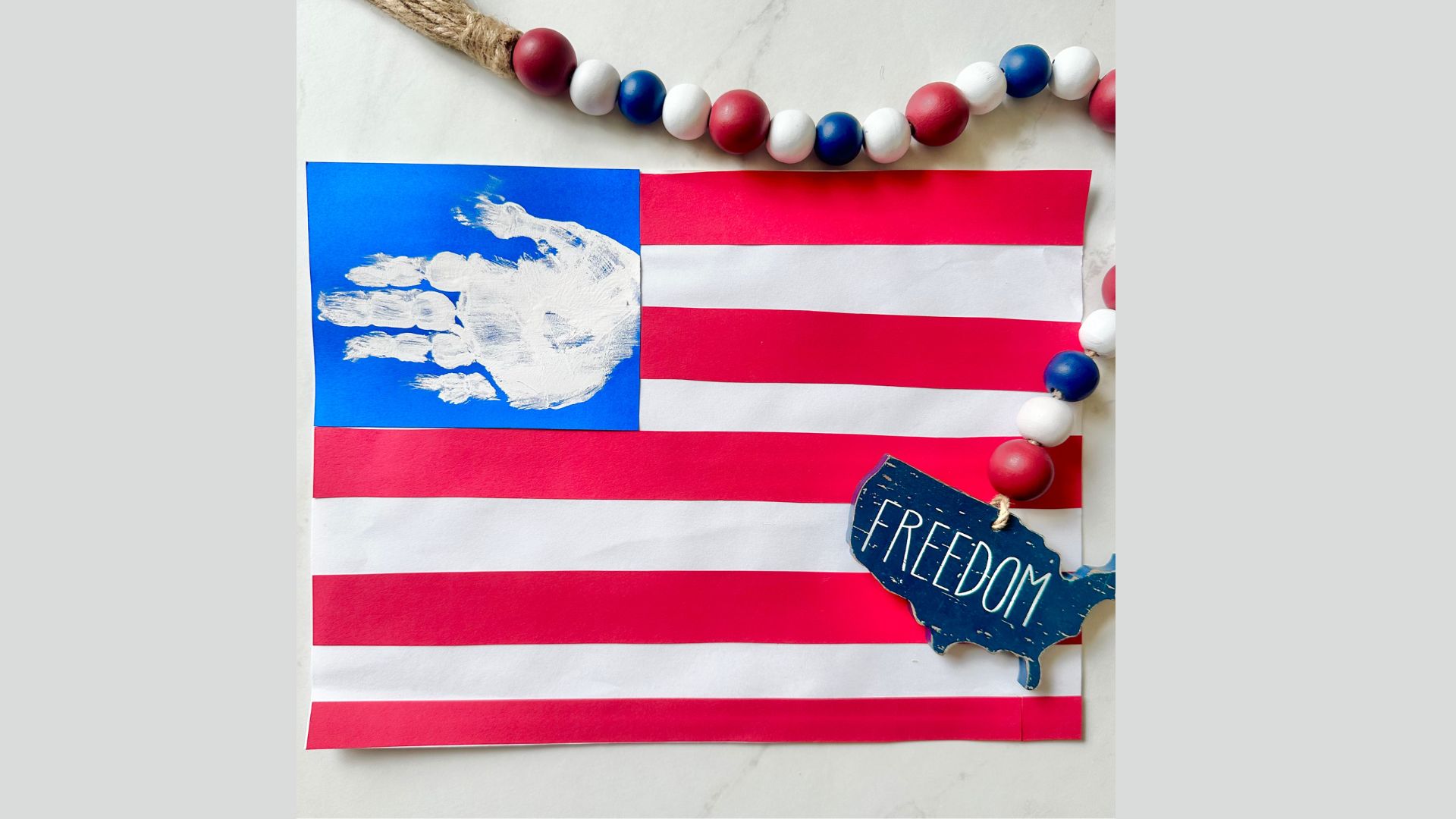 Handprint American flag craft for kids, featuring colorful handprints arranged to form the stars and stripes of the flag.