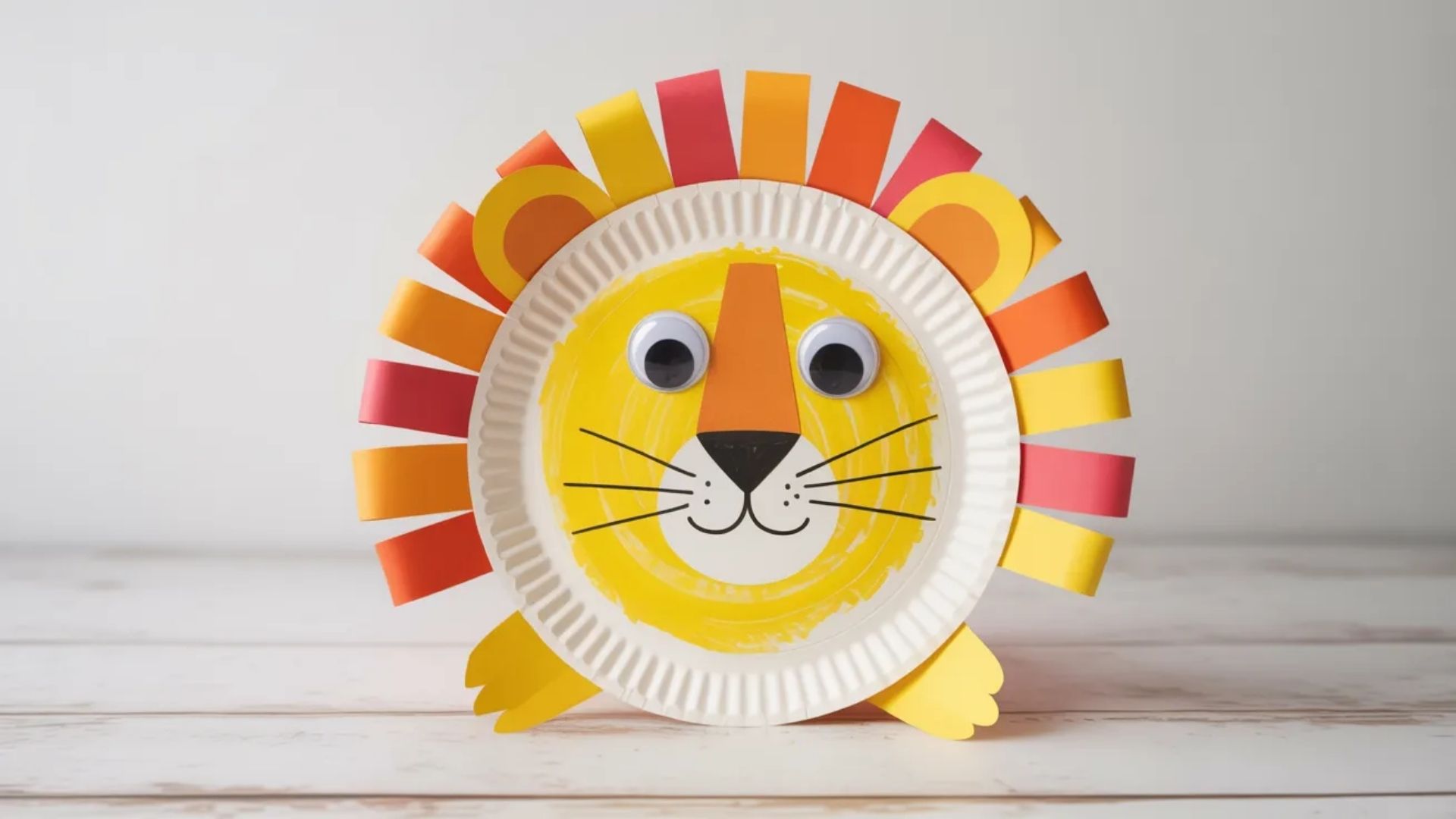 Colorful paper plate lion craft for kids, featuring a cheerful face and mane made from various craft materials.
