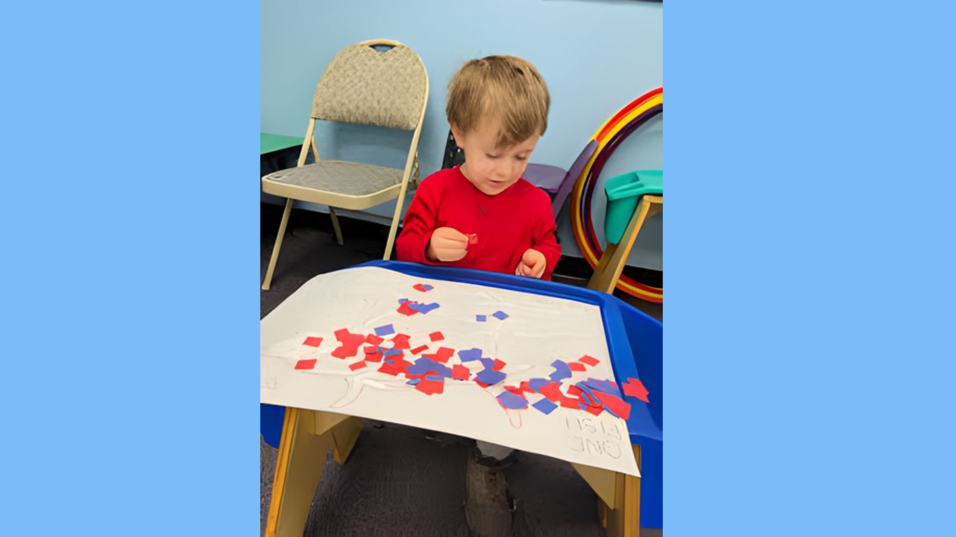 A young boy is focused on assembling a colorful puzzle on a table.