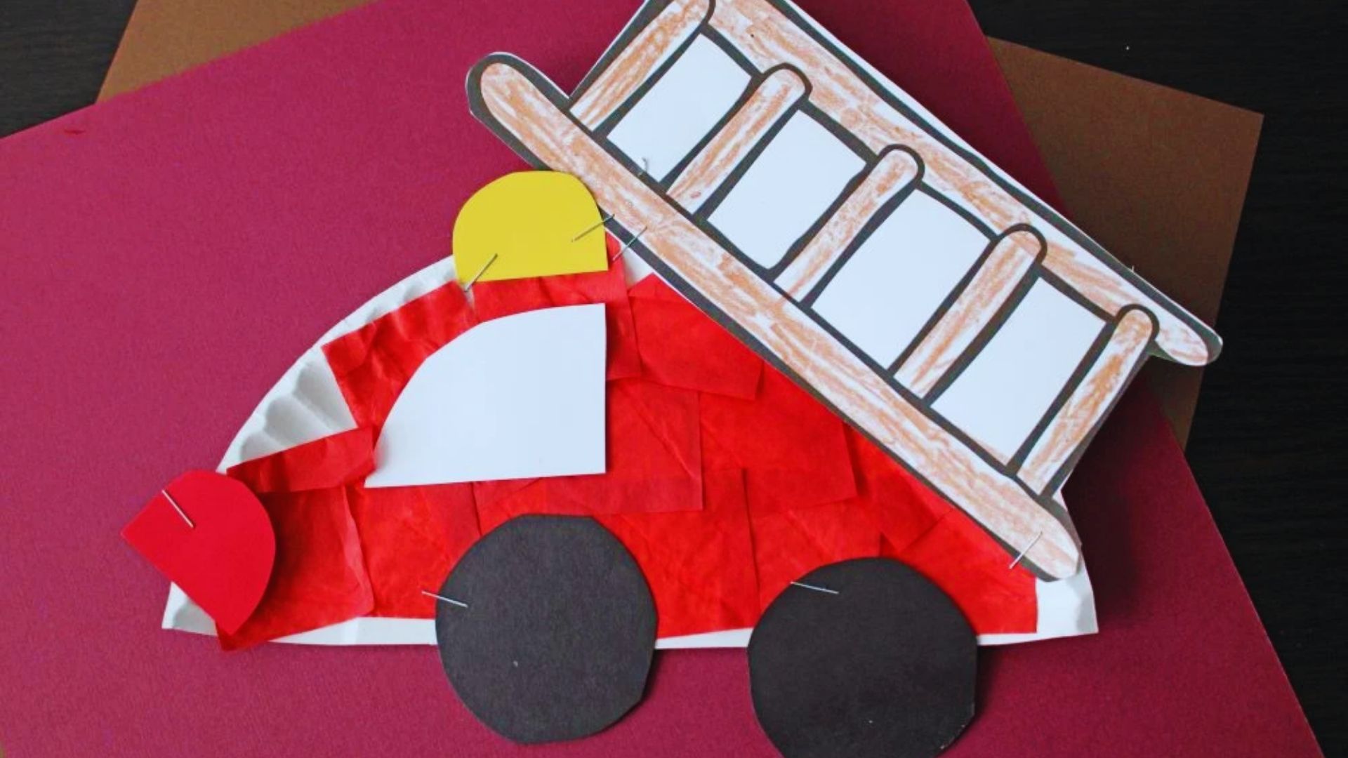 Colorful paper plate fire truck craft for kids, featuring wheels and a ladder, designed for creative play and learning.