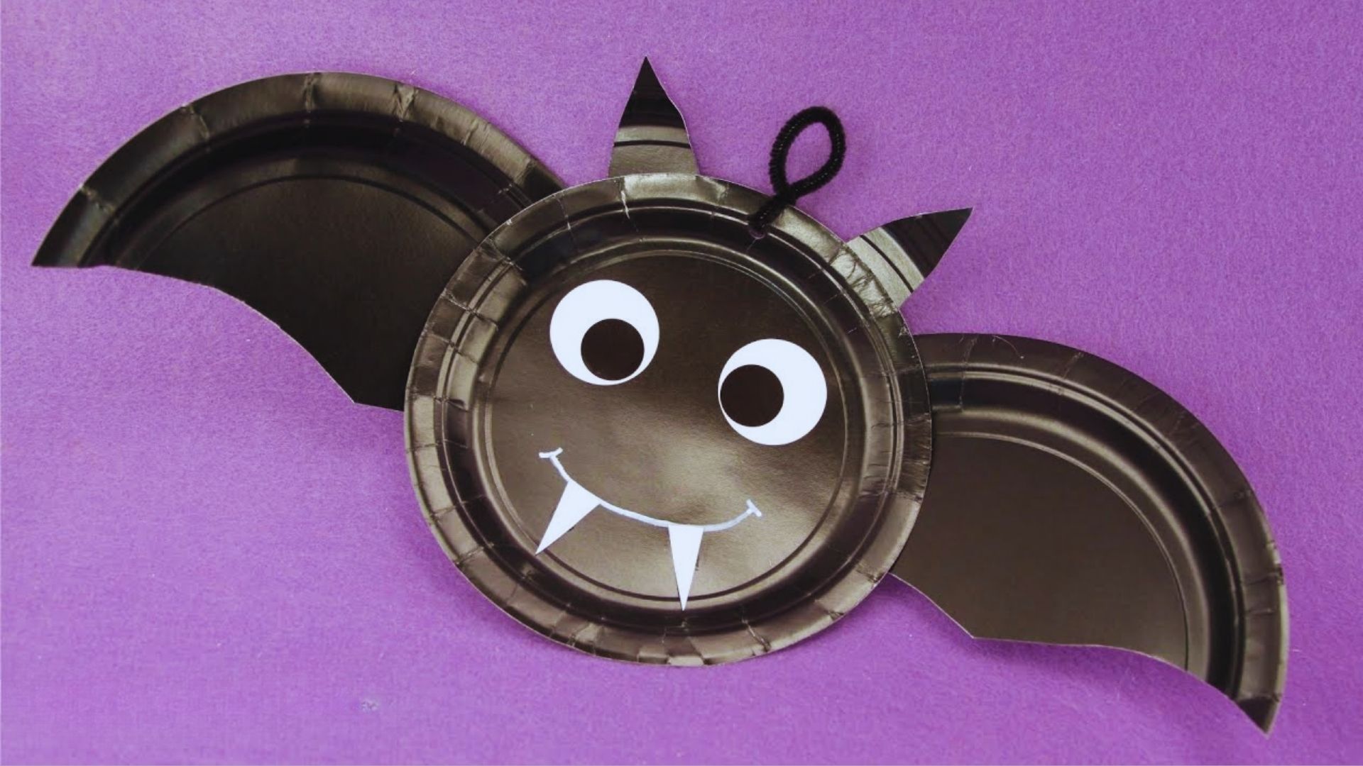 A Halloween-themed paper plate featuring a bat face design, perfect for festive celebrations.