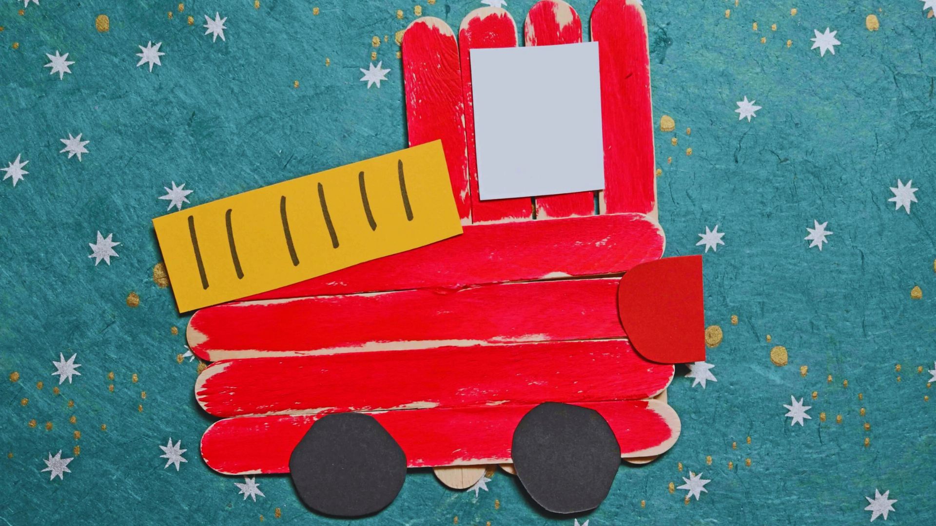 A model fire truck crafted from red popsicle sticks, showcasing intricate details and a playful design.