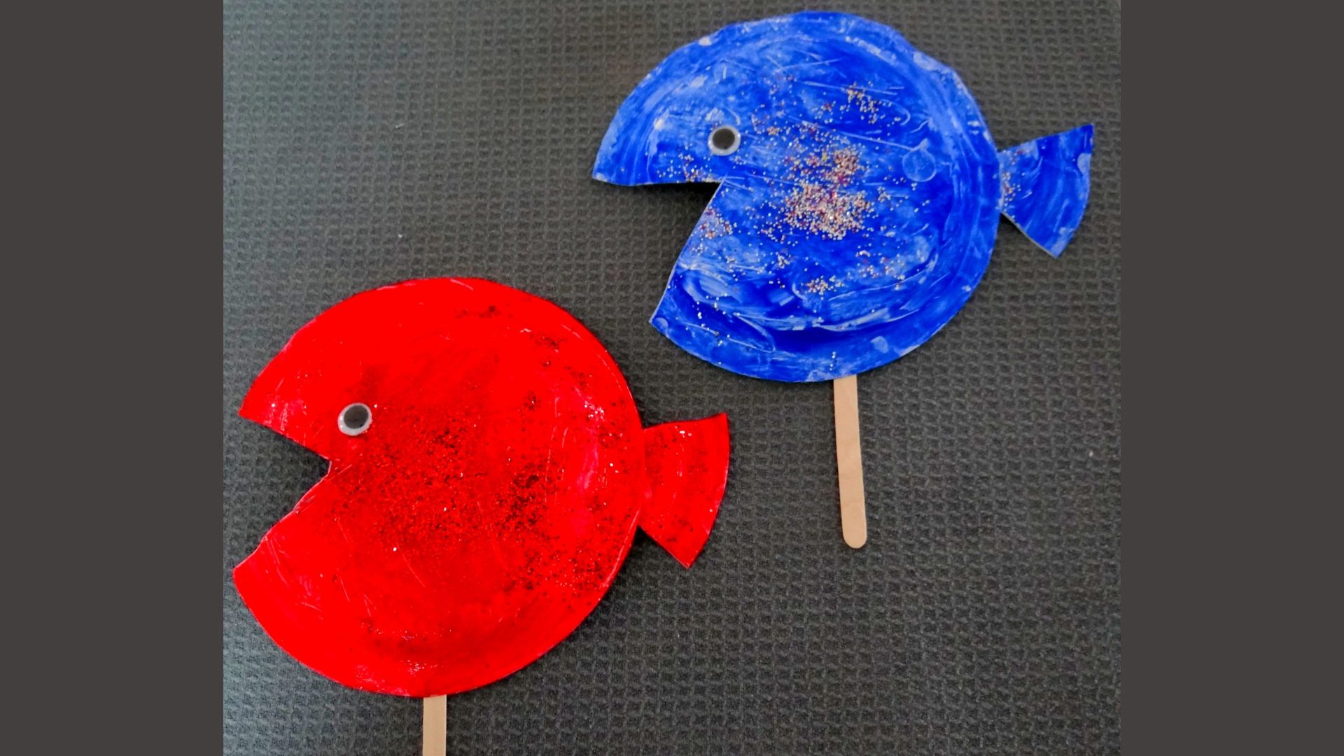 using scissors to snip paper for the Red Fish Blue Fish paper plate project.
