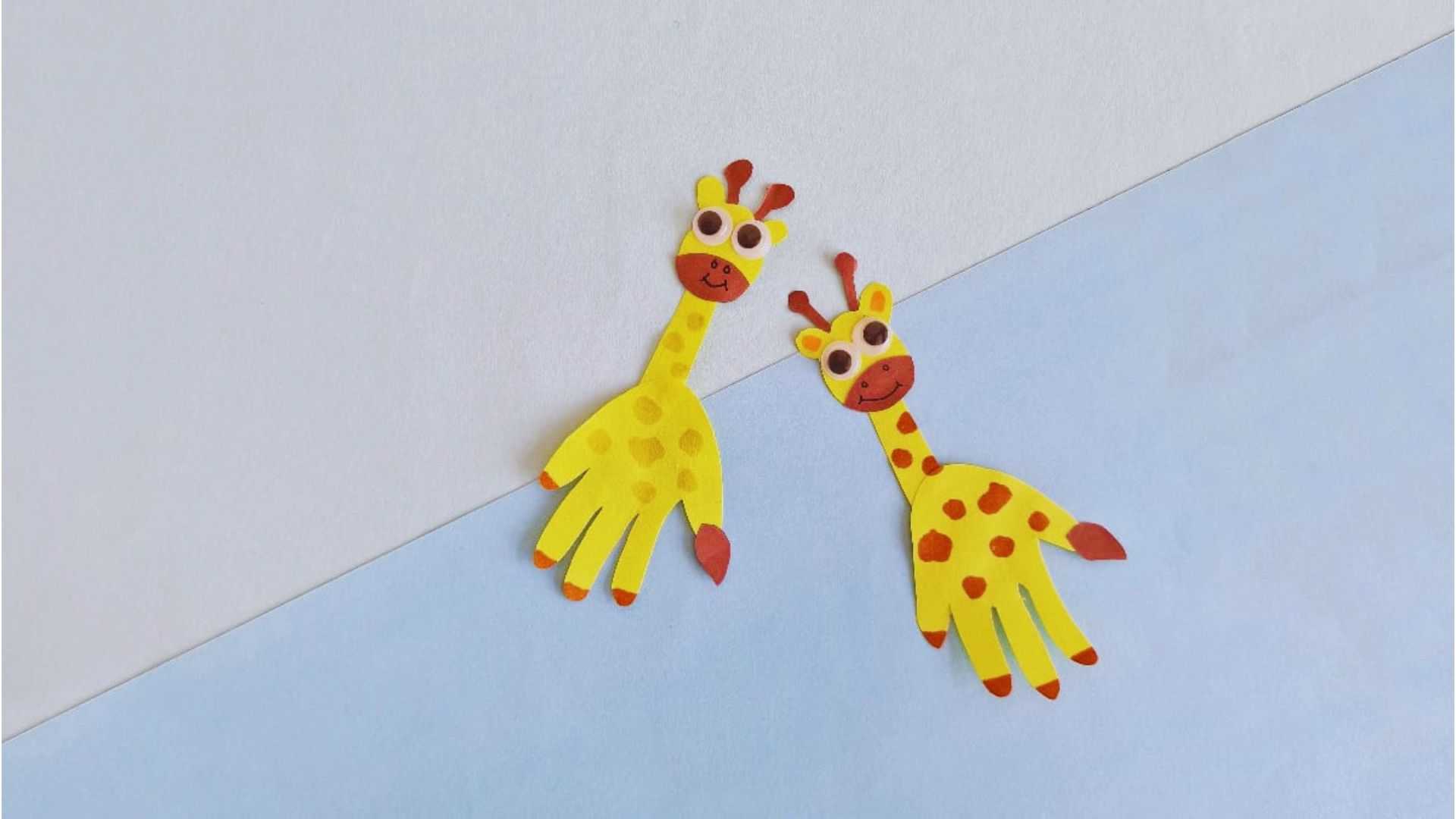 Two giraffes made of paper are positioned on a blue and white background, emphasizing their artistic cutout style.