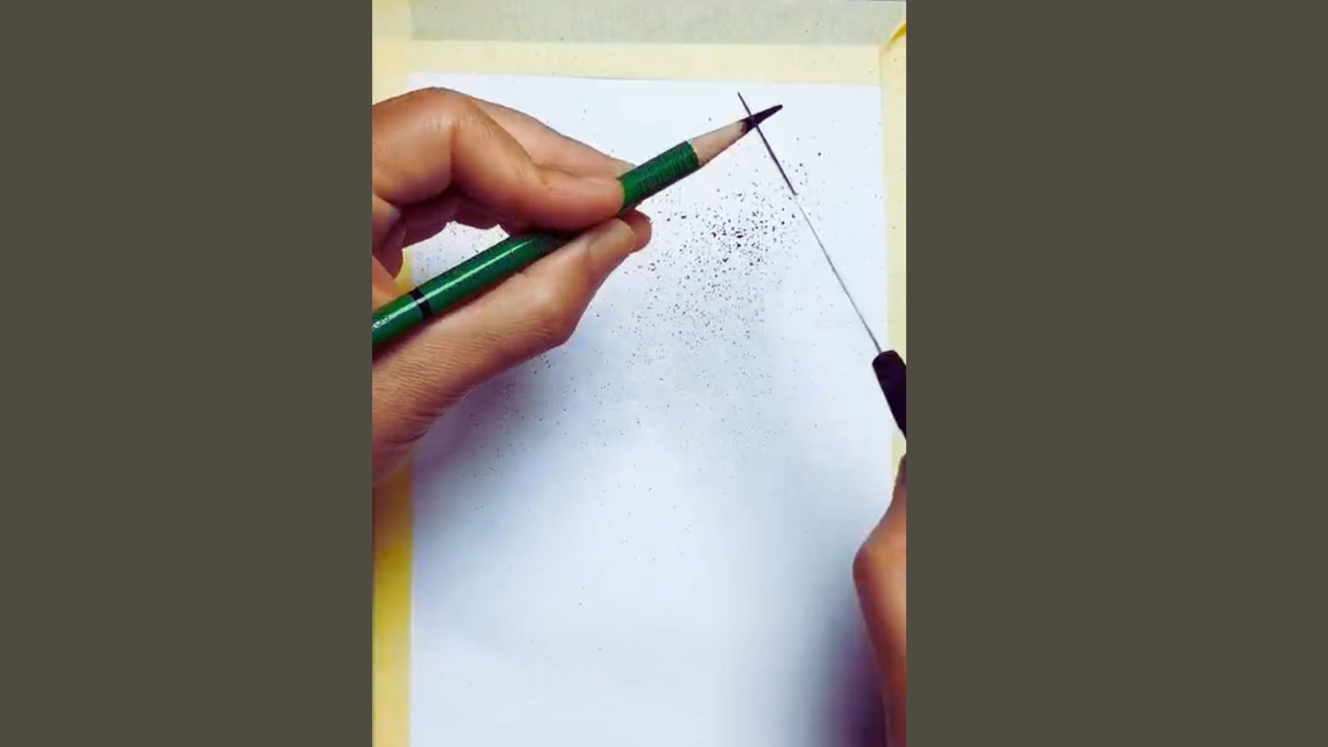 A person is sketching on a piece of paper with a pencil, focused on their drawing.