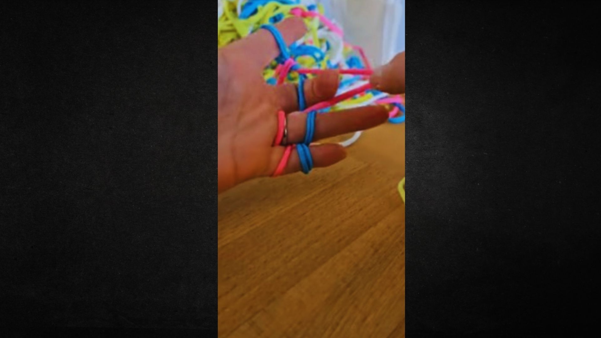 A hand displays a collection of colorful rubber bands, highlighting their bright hues and flexible texture.