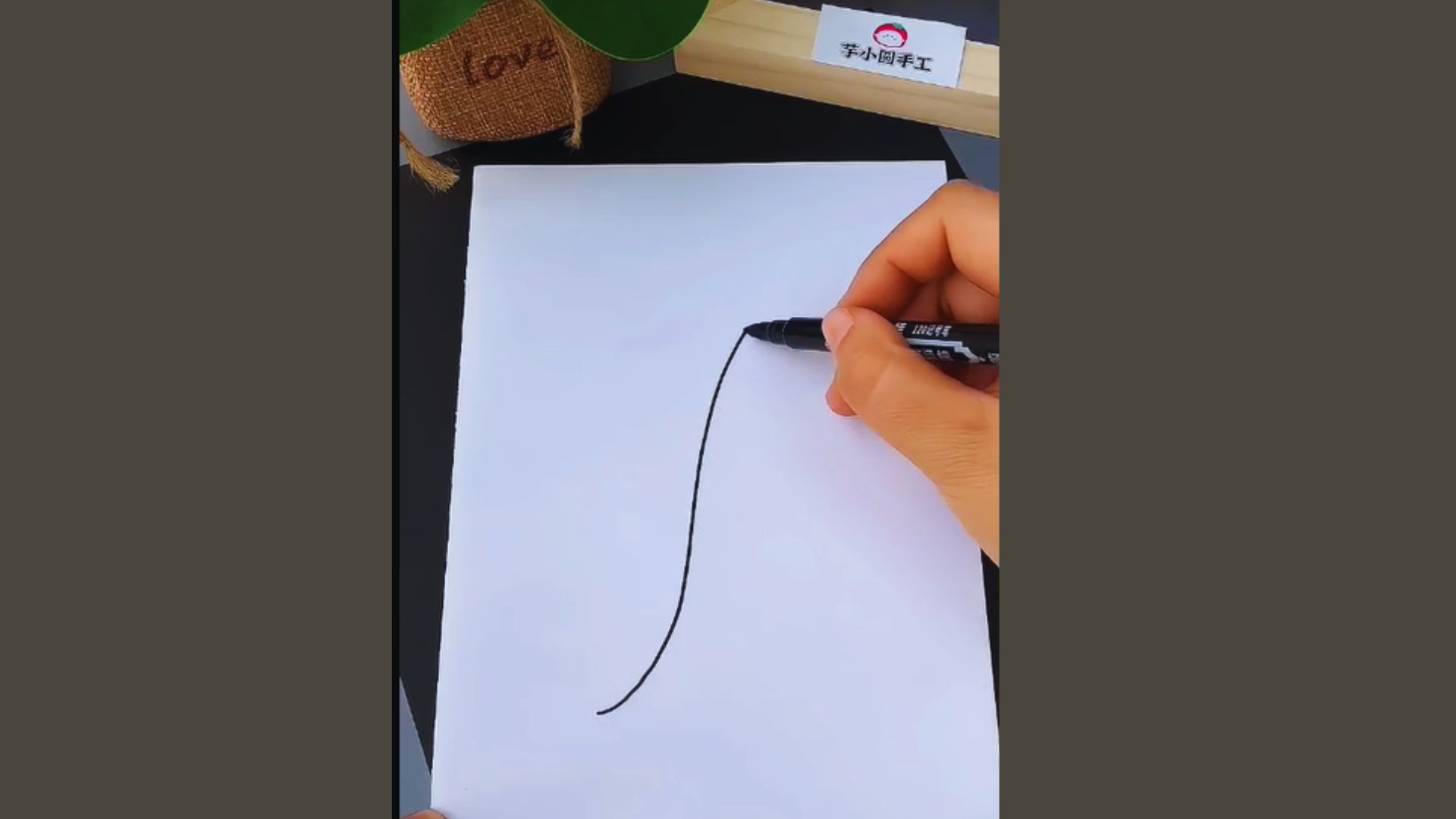 A person is creating a line on paper with a pencil in hand.