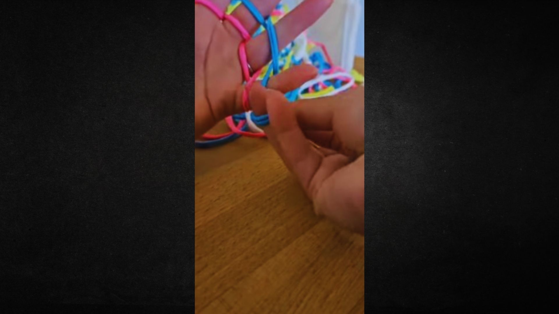 A person holds a vibrant string of beads, showcasing a variety of colors and patterns in their hands.