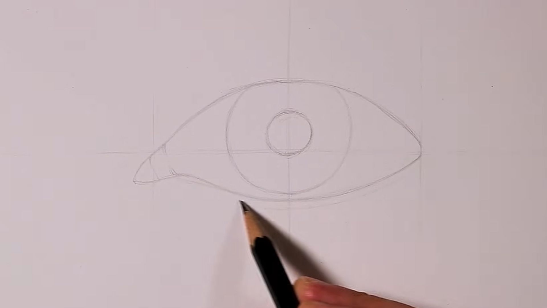 A person is using a pencil to draw a circle on a sheet of paper.