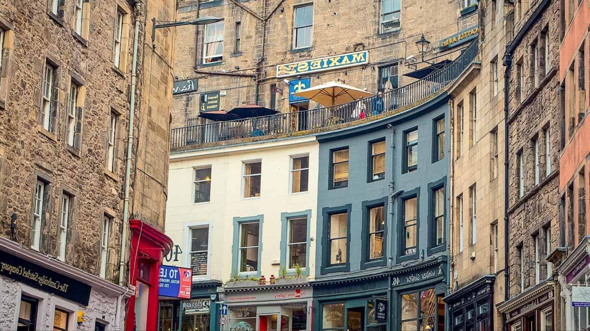 . A narrow street in Edinburgh, Scotland, lined with historic buildings and cobblestones, showcasing the city's charm.