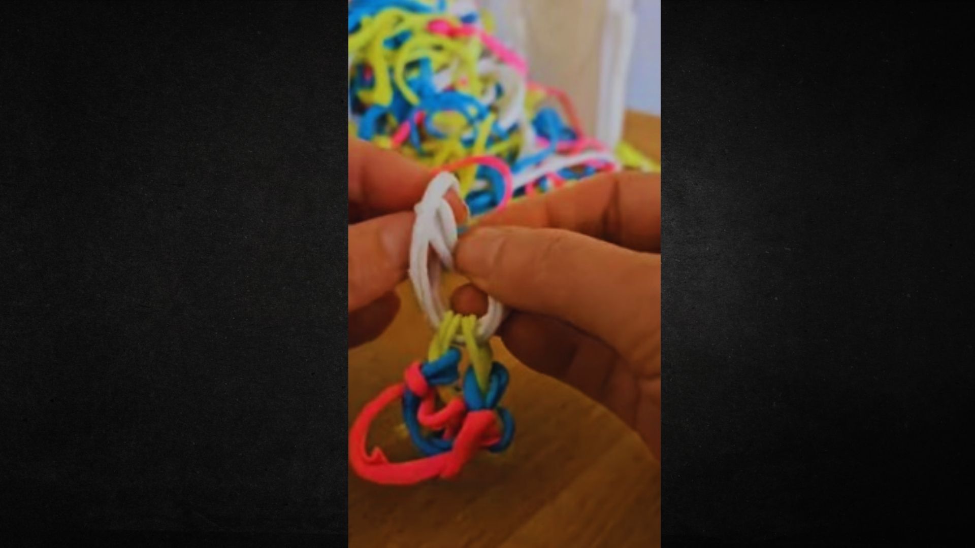A person holds a vibrant string of beads, showcasing a variety of colors and patterns in their hands.