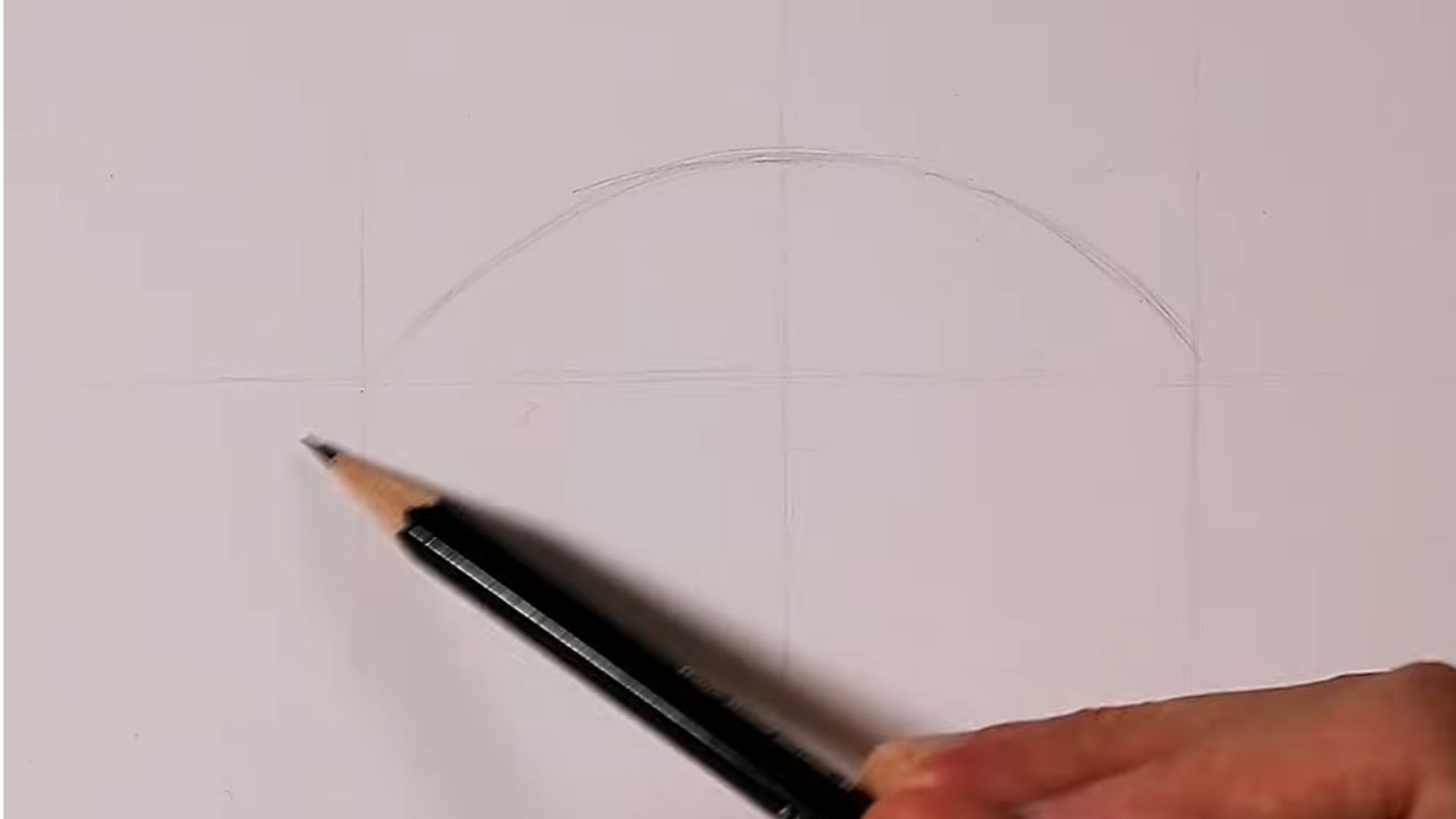 A hand drawing a perfect circle on paper with a pencil, showcasing precise and careful movements.