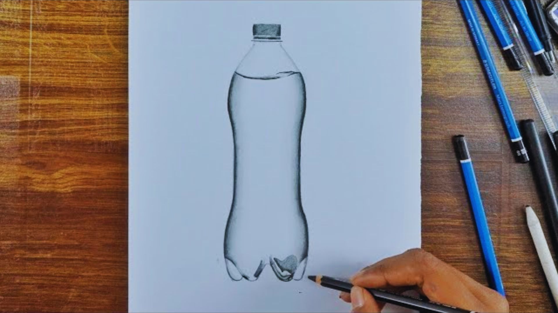 A person sketches a bottle using a pencil on a blank sheet of paper.