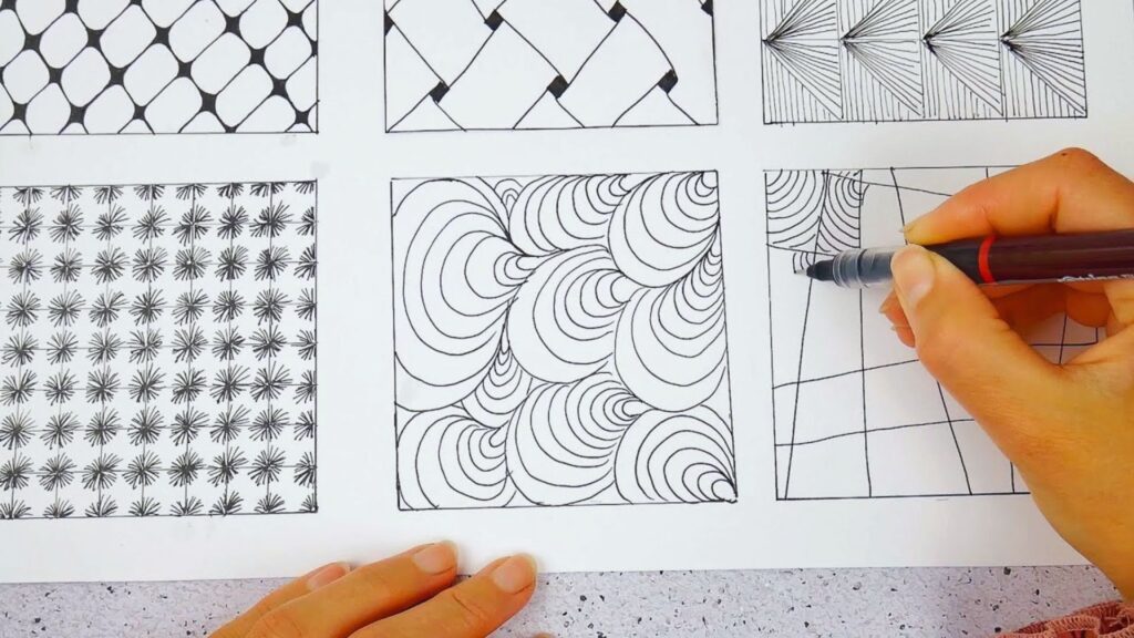 A person engaged in drawing on a sheet of paper with a pen, illustrating their artistic process.