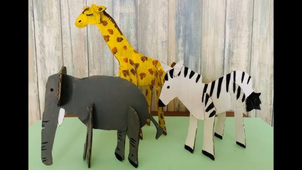 Three wooden animals, a bear, a rabbit, and a fox, are standing side by side on a wooden surface.