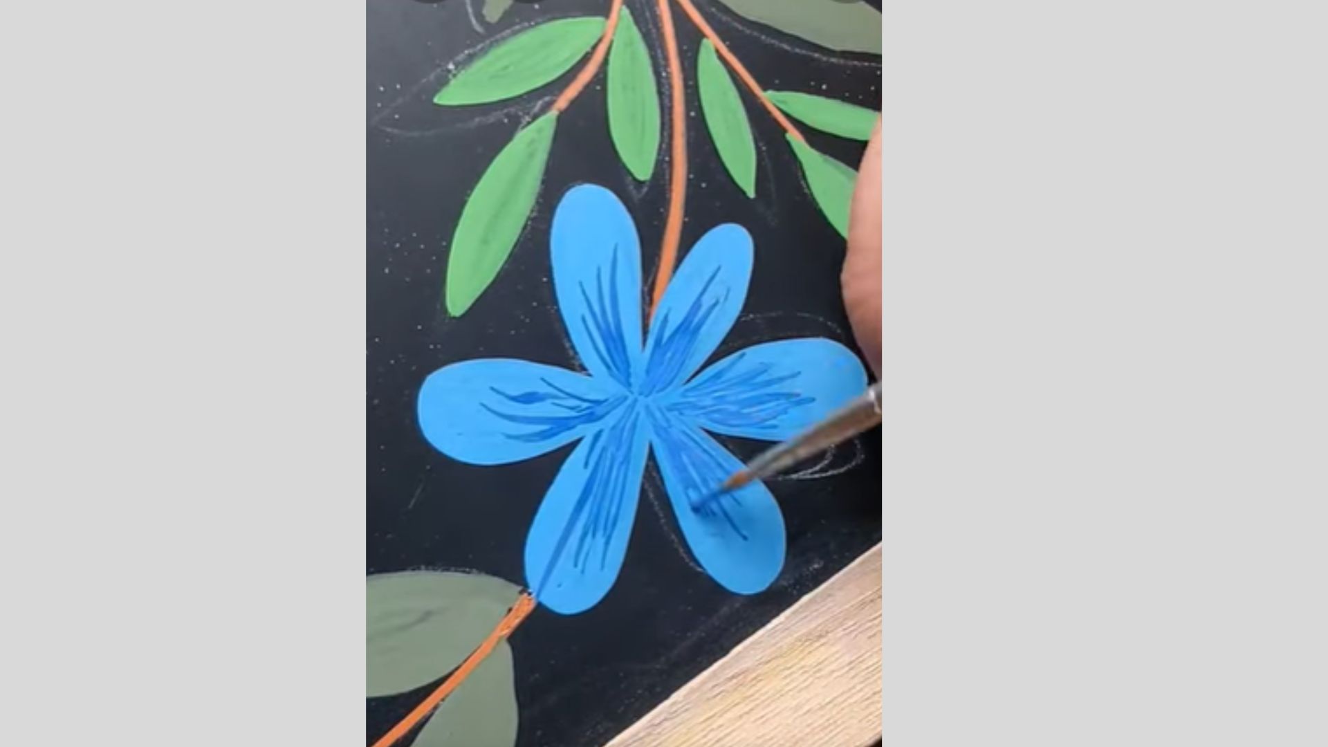 Blue flower detailed with darker strokes, adding depth and texture carefully.
