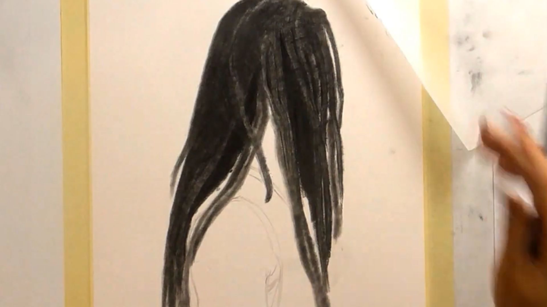 "A person sketching a black and white illustration of a woman's flowing hair on a blank canvas."