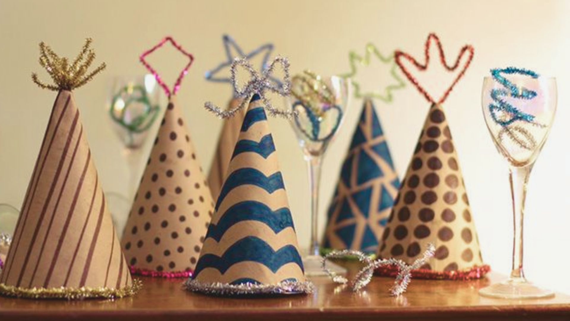 Handmade paper party hats with stripes, dots, and chevron patterns.