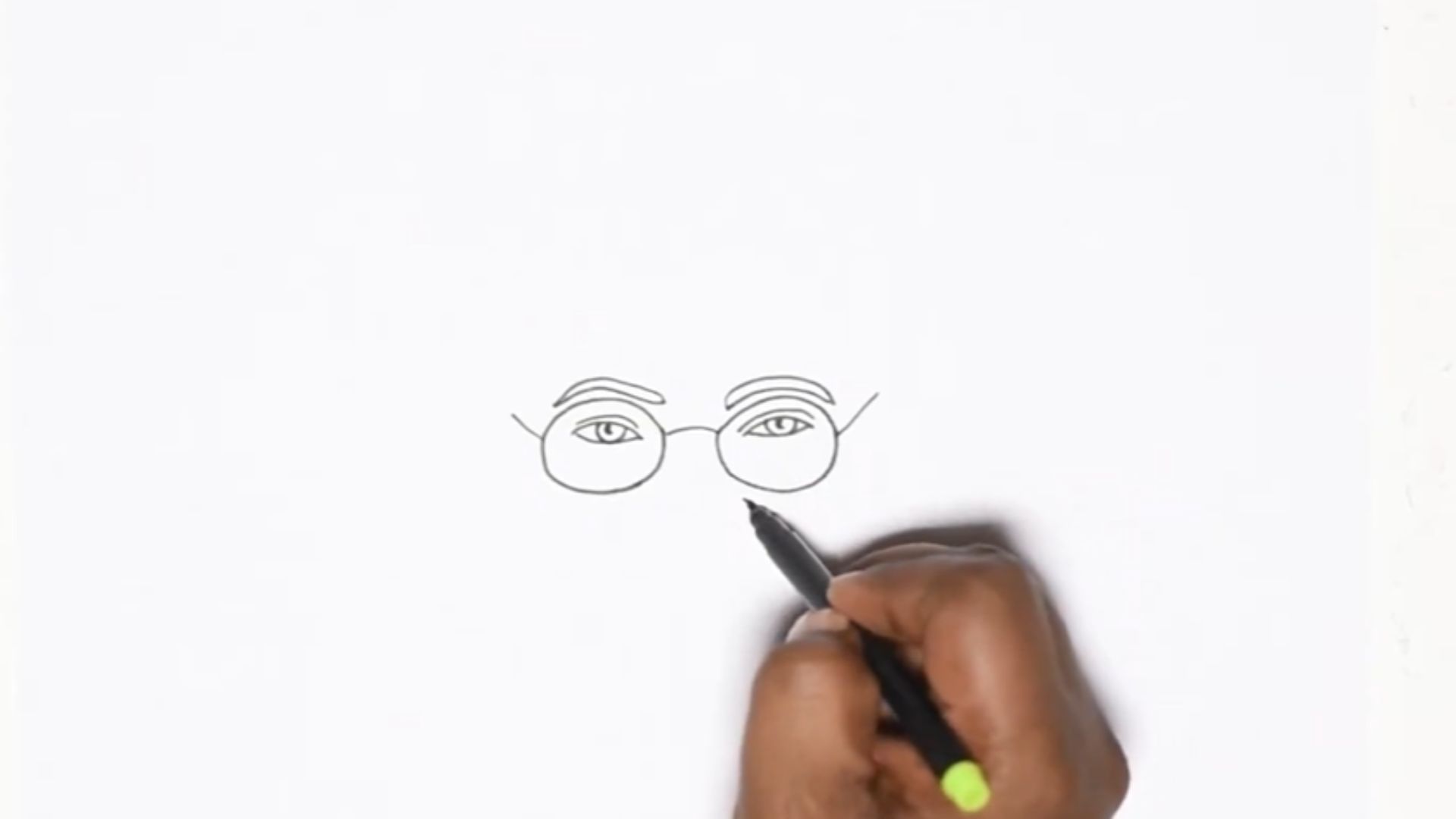 "An individual sketching a face with a marker, concentrating on the features and expression on the paper."