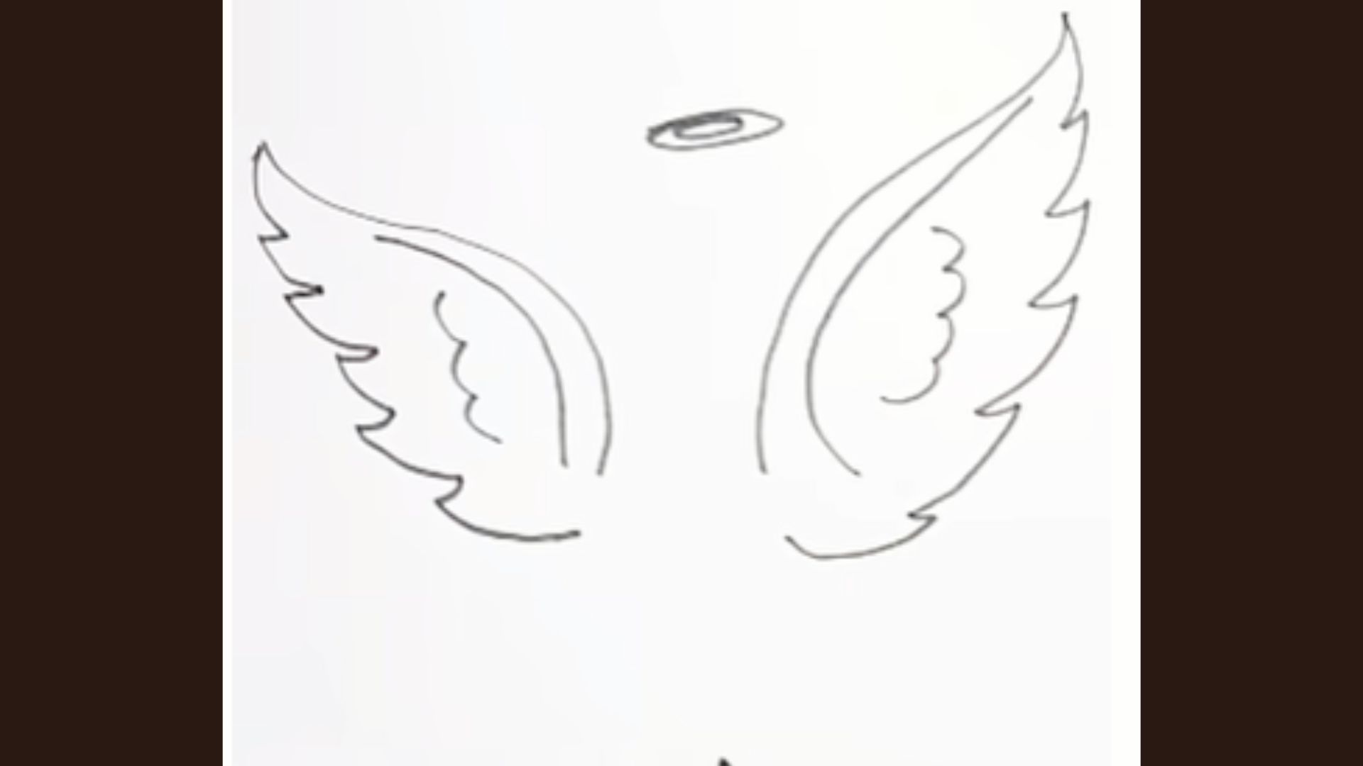 Angel face outline and small halo drawn between the two wings.