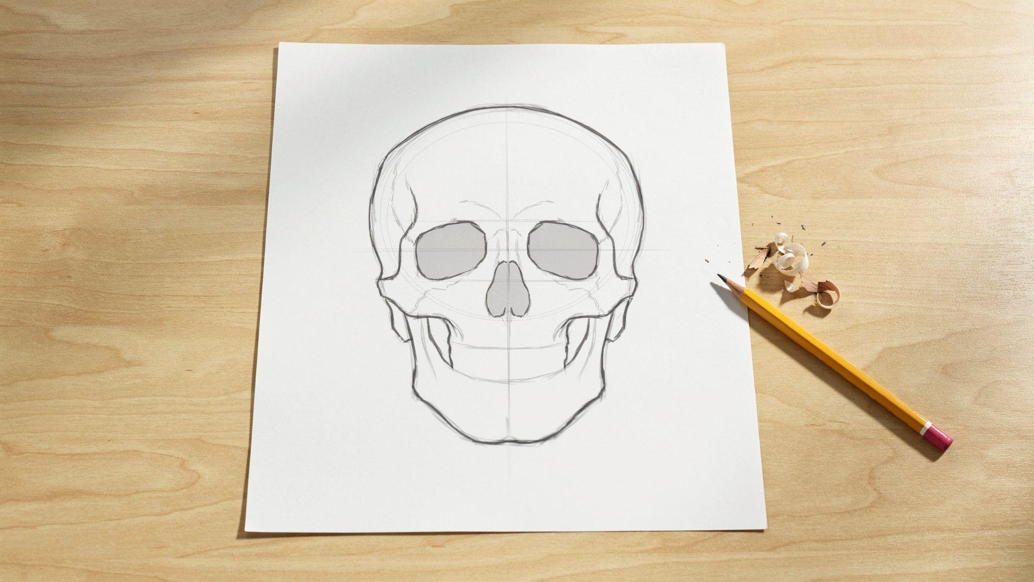 Simple skull drawing with guideline grid, pencil and eraser on light wood tabletop.