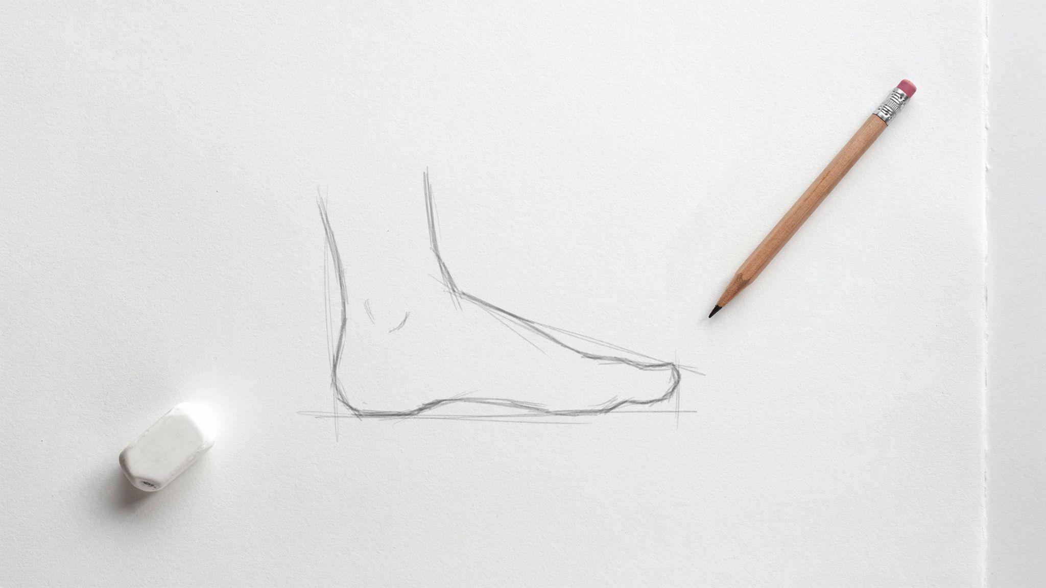 Beginner step of boot sketch on notebook with pencil, eraser, and eraser.