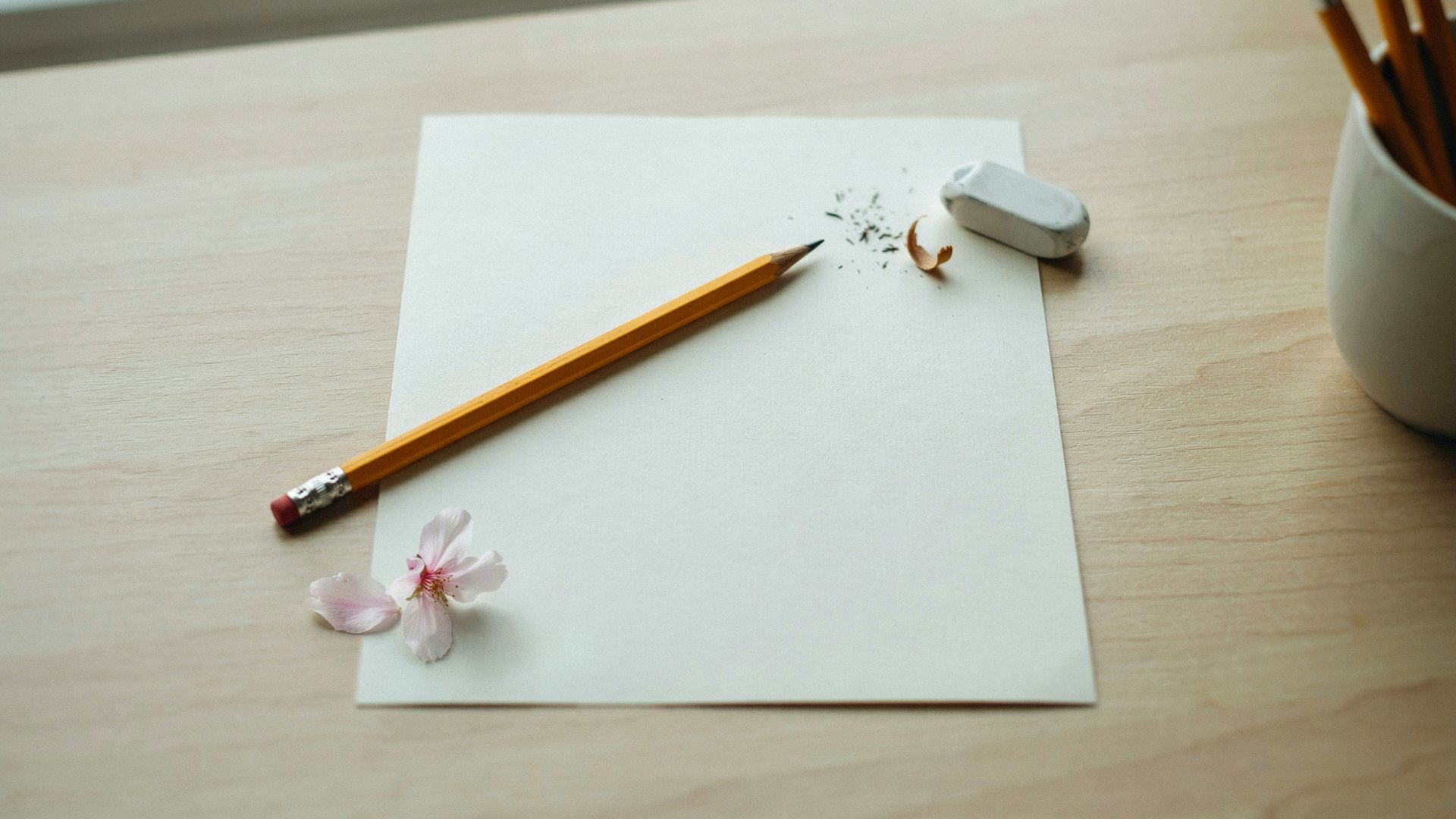 HB pencil, soft eraser, and drawing paper arranged for a cherry blossom drawing project.