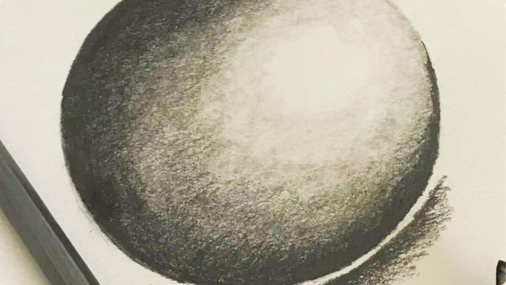 Detailed pencil shading of a 3D sphere on white paper with a cast shadow.